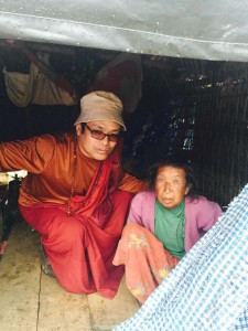 One of the monks of the Trungram Monastery brings aid to a Nepalese woman.
